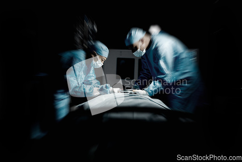 Image of Doctors, night surgery and hospital theater with patient and surgeon team for emergency, teamwork and trust. Medical man and woman in dark for life saving, healthcare and health insurance emergency