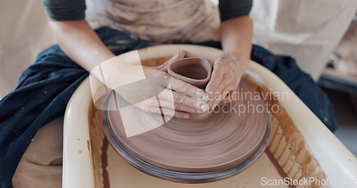 Image of Pottery, art and hands on a potter wheel with artist spinning clay in creative class, workshop or studio. Creativity, handicraft and closeup of a sculptor working on ceramic design, craft or creation