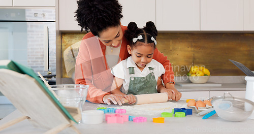 Image of Mother, girl learning baking in kitchen and rolling flower dough on counter to cook cookies for fun, learning and development. Happy mom, black child with smile and teaching daughter to bake together