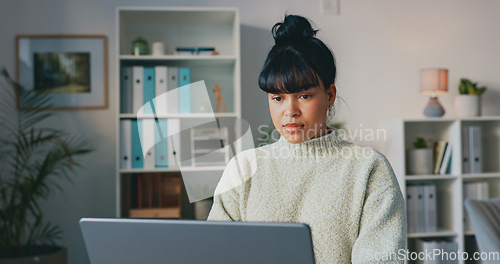 Image of Business woman, typing on laptop and doing research while writing email or article and sitting in a modern office. Serious, creative entrepreneur using technology and online computer communication.