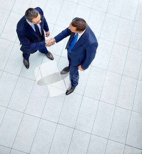 Image of Top view, business people or handshake in modern office, finance company or investment startup for insurance deal. Men, shaking hands or partnership gesture for corporate workers in welcome greeting