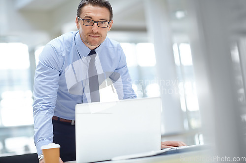 Image of Portrait, laptop and mission with a business man at work in his office for research or innovation. Computer, mindset and vision with a male employee working on a report or planning for success