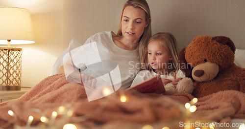 Image of Story, book and reading mother with child in bedroom for child education, home learning or language development together. Mom and girl kid with creative literature for kindergarten with lamp lights