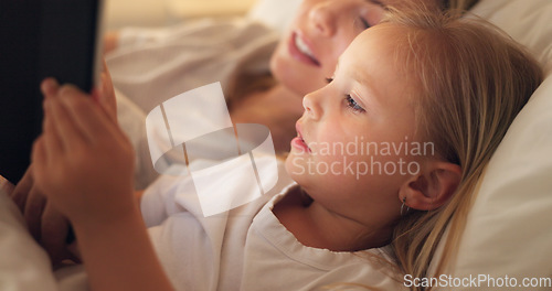 Image of Tablet, mother and child on the internet in bed, streaming a movie or reading a book on the web at night. Education, learning and games on technology for a girl and her mom together in the bedroom