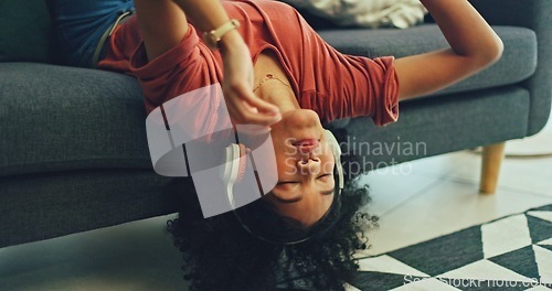 Image of Headphones, listening and dance of black woman on a sofa excited for subscription service, technology and home connection. Happy, relax and girl portrait dancing on couch while listening to music app