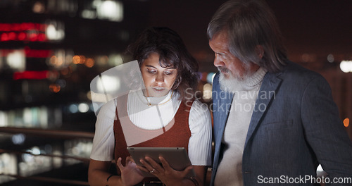 Image of Business team, tablet and night on city building rooftop talking global networking, digital marketing and social media. Man and woman with 5g network on mobile stock market app for innovation idea