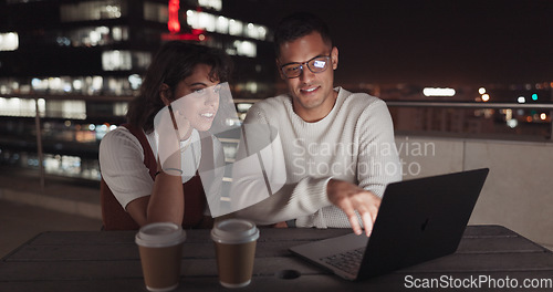 Image of Laptop, collaboration and night with a business team working together on balcony in the city. Teamwork, computer and overtime with a man and woman employee at work late on a project deadline