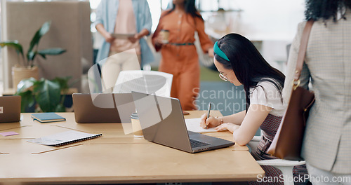 Image of Asian woman, laptop and writing in notebook for planning strategy, schedule management or finance checklist in office. Employee, reading email communication and notes for creative startup company