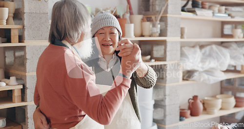 Image of Pottery, creative and senior couple talking about art dancing together in a studio class. Elderly Asian man and woman hugging with love while learning and working with clay on a date