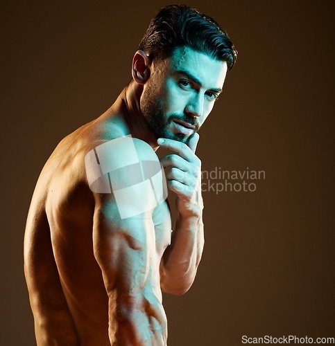 Image of Sexy, muscular and portrait of a man in a studio with a hot, sensual and attractive pose. Seductive, handsome and young strong male model with biceps, body and muscles posing by a brown background.