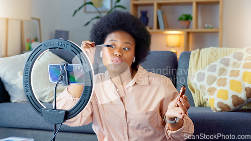 Image of Afro beauty influencer, vlogger or podcast host talking, using phone to film live stream makeup tutorial with new mascara makeup. Excited woman using technology to promote cosmetic product from home