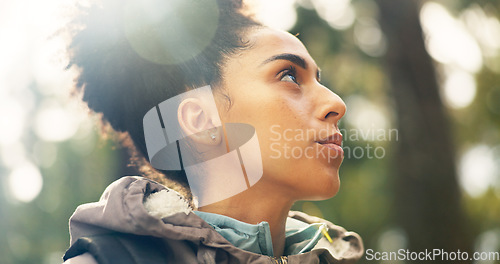 Image of Hiking, thinking and adventure with a black woman in nature, sightseeing while walking on a trail outdoor. Freedom, travel and health with a young female hiker out for discovery and exploration