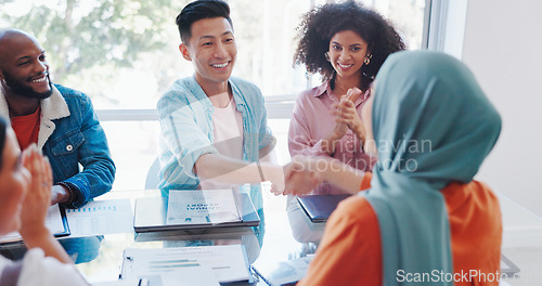 Image of Handshake, success or happy employees meeting kpi goals, bonus achievement or sales target in office. Muslim, black woman or black man shaking hands with Japanese worker clapping for a business deal