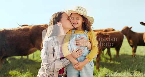 Image of Farming, child and mother with kiss on a farm during holiday in Spain for sustainability with cattle. Portrait of happy, smile and travel mom and girl with love while on vacation on land with cows