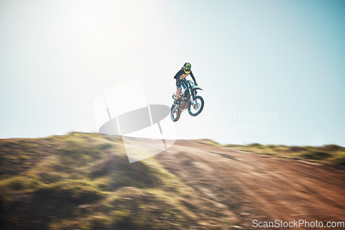 Image of Motorbike, cycling and jump on blue sky mockup for speed challenge, sports and fearless athlete. Driver, air stunt and driving over hill with adrenaline, competition adventure and motorcycle power