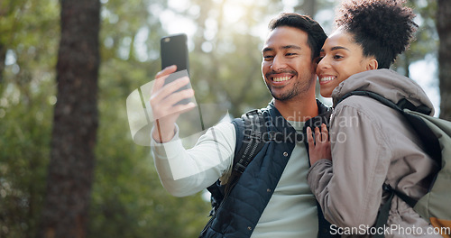 Image of Hiking, selfie and young couple in forest smiling, happy and enjoy nature together. Fitness, wellness and Asian man with black woman taking picture with phone on adventure, trekking and walk in woods