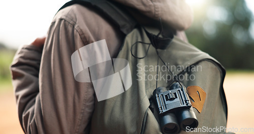 Image of Traveler, bag and adventure walk to explore, sightsee or scout trip in the outdoors of nature. Closeup of adventurer walking for backpacking, travel or tour with binoculars in the natural environment
