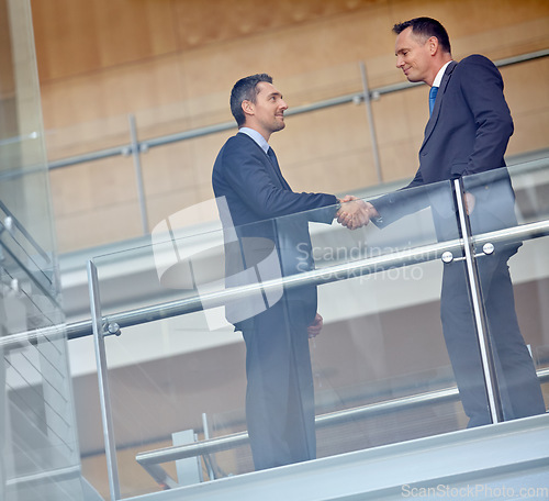 Image of Low angle, business people and corporate handshake in modern office, finance company and investment deal startup. Men, shaking hands and partnership gesture for insurance workers in welcome greeting