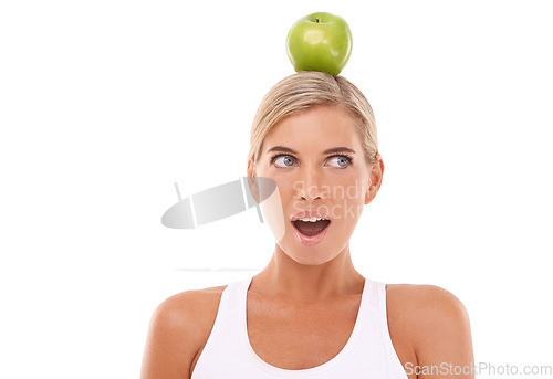 Image of Woman, wow and apple on head in studio for wellness, diet and balance by white background. Isolated model, fruit and surprise expression face for vitamin c, natural nutrition and healthy organic food