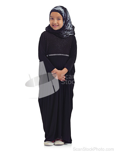 Image of Islamic clothes, young child and smile standing in white background for culture happiness, religion awareness or empowerment. Muslim girl, happy and religious fashion or hijab isolated in studio