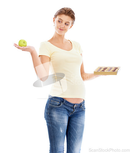 Image of Woman, pregnant and studio with choice, apple or chocolate for nutrition, health and wellness. Pregnant woman, healthy fruit or candy with decision for diet, healthcare and isolated white background