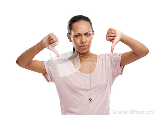 Image of Woman, upset and thumbs down with unhappy expression for disagreement, wrong or fail against a white background. Portrait of isolated female model showing down thumbs in disapproval, no or failure