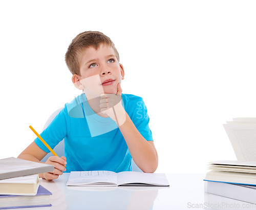 Image of Young boy, writing and thinking with books at desk for school, education study and student knowledge. Paper, working and child focus for learning, creative drawing or creativity idea vision in studio