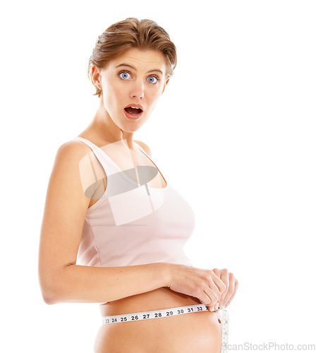 Image of Portrait, surprise and shocked pregnant woman with measuring tape on stomach, on white background. Health, wellness and pregnancy, surprised woman measuring growth progress of baby in belly in studio