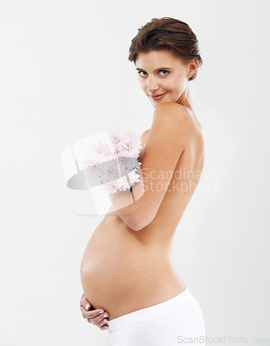Image of Pregnancy, photo shoot and portrait of a woman with flowers on a white background in studio. Smile, stomach and pregnant woman with a bouquet of Deutzia for love of a child on a studio background