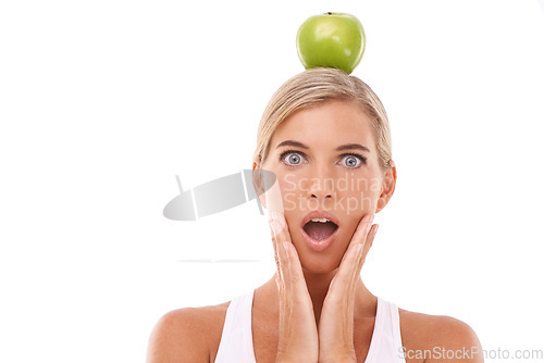 Image of Woman, surprise and apple on head in studio for wellness, nutrition and balance by white background. Isolated model, fruit and wow face portrait for vitamin c, natural diet and healthy organic food