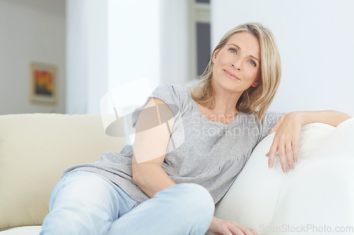 Image of Relax, portrait and woman on a sofa in the living room for rest, relaxing and chilling at home. Comfort, calm and mature female with positive mindset from Australia sitting on the couch in her house.