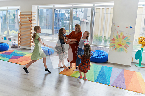 Image of A child hugging a teacher in a modern kindergarten