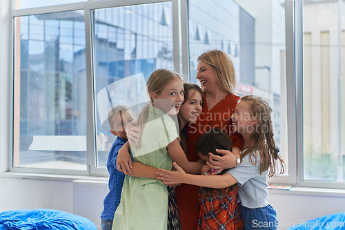 Image of A child hugging a teacher in a modern kindergarten