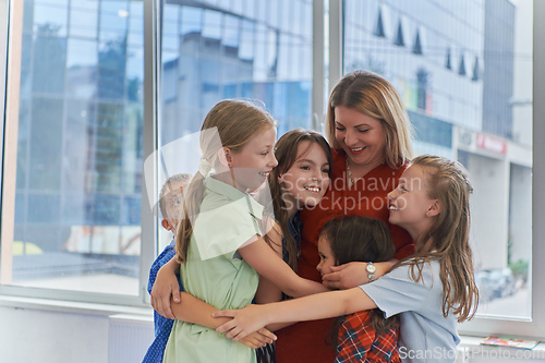 Image of A child hugging a teacher in a modern kindergarten