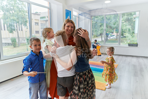 Image of A child hugging a teacher in a modern kindergarten