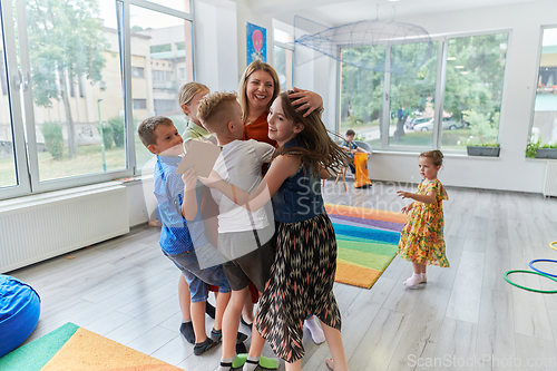 Image of A child hugging a teacher in a modern kindergarten