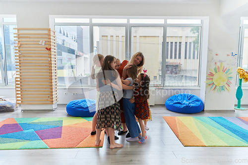 Image of A child hugging a teacher in a modern kindergarten