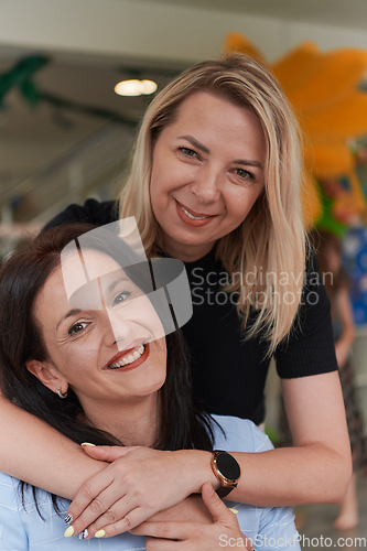 Image of Two women share a heartfelt embrace while at a preschool, showcasing the nurturing and supportive environment for learning and growth