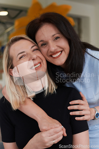 Image of Two women share a heartfelt embrace while at a preschool, showcasing the nurturing and supportive environment for learning and growth