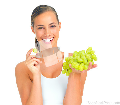 Image of Health, wellness and woman with grapes in a studio for a healthy snack, nutrition diet or craving. Wellbeing, weightloss and portrait of young female model eating fruit isolated by a white background