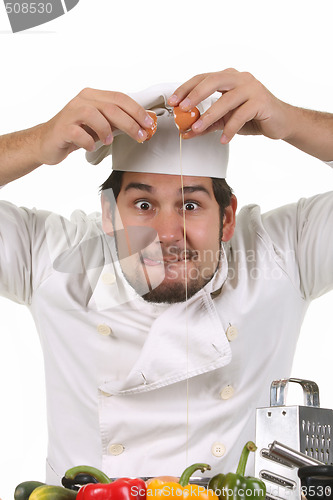 Image of young funny chef cracking an egg