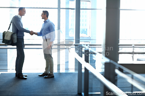 Image of Business men, handshake and partnership deal in hotel lobby, modern office or airport lounge in CRM team meeting. Corporate people, employees and shaking hands in collaboration, agreement or success