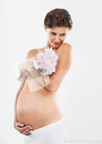 Image of Pregnancy, abdomen and woman with flowers for motherhood on a white background in studio. Smile, stomach and pregnant woman with a bouquet of Deutzia for love of a child on a studio background