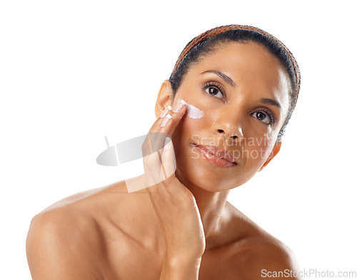 Image of Face, beauty cream and skincare of woman in studio on a white background. Thinking, makeup cosmetics and young female model apply facial lotion, creme or moisturizer for healthy skin and wellness.