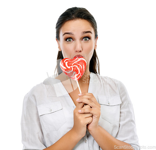 Image of Candy, portrait and happy woman with a lollipop in a studio for a sweets craving, dessert or sugar. Happiness, snack and young female model eating heart shape sweet while isolated by white background