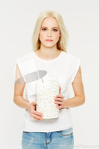 Image of Portrait, pills and medicine with a model woman holding a jar in studio on a gray background for healthcare. Medical, supplements and medication with a serious young female holding a glass container