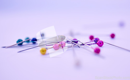 Image of Closeup, sewing pin and design in studio by purple background for clothing manufacturing in factory. Macro, metal needles or table for fashion, clothes or workshop for tailor, designer or seamstress