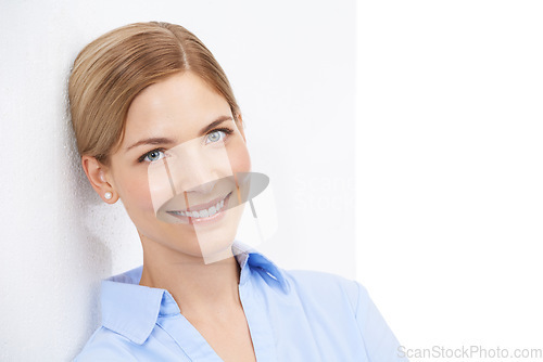 Image of Portrait of a business woman leaning on a wall in studio with a stylish, luxury and fashion outfit. Happy, smile and female model from Australia with corporate clothes isolated by a white background.