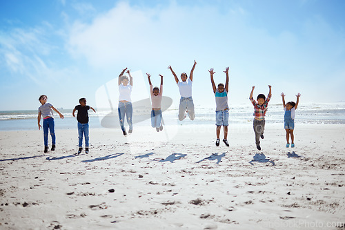 Image of Big family, beach jump and adventure for holiday, sky and bonding for interracial diversity by waves. Happy family, mom and jumping with hands in air for solidarity, care or love on vacation by sea