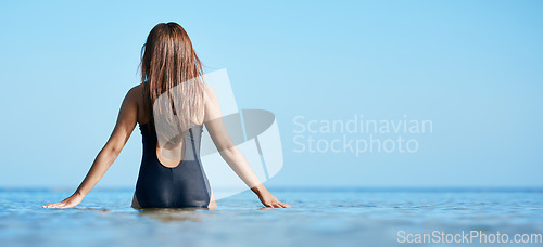 Image of Back, young woman swimming at the beach on vacation in Mauritius and horizon of blue ocean water in summer. Calm female tourist in sea, freedom of travel lifestyle or relaxing on coastal destination